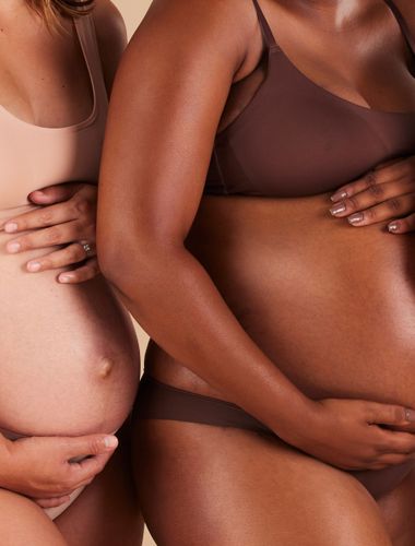 women standing showing their pregnant bellies